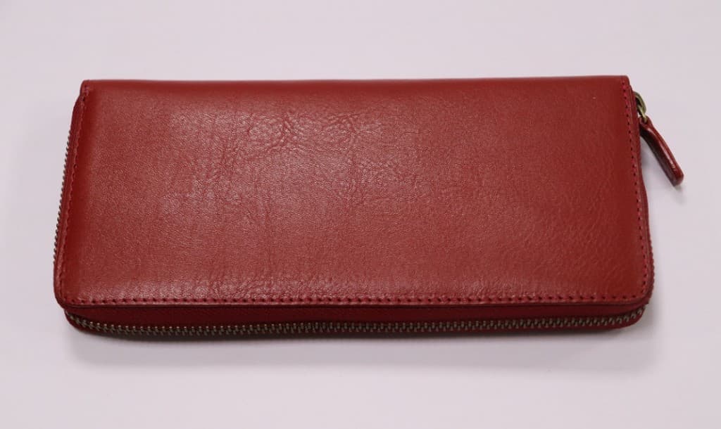 Long red pebbled leather zip-around wallet with matching leather pull tab