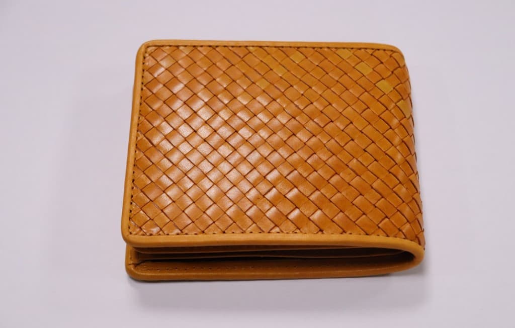 Honey-tan woven leather bifold wallet with rounded corners
