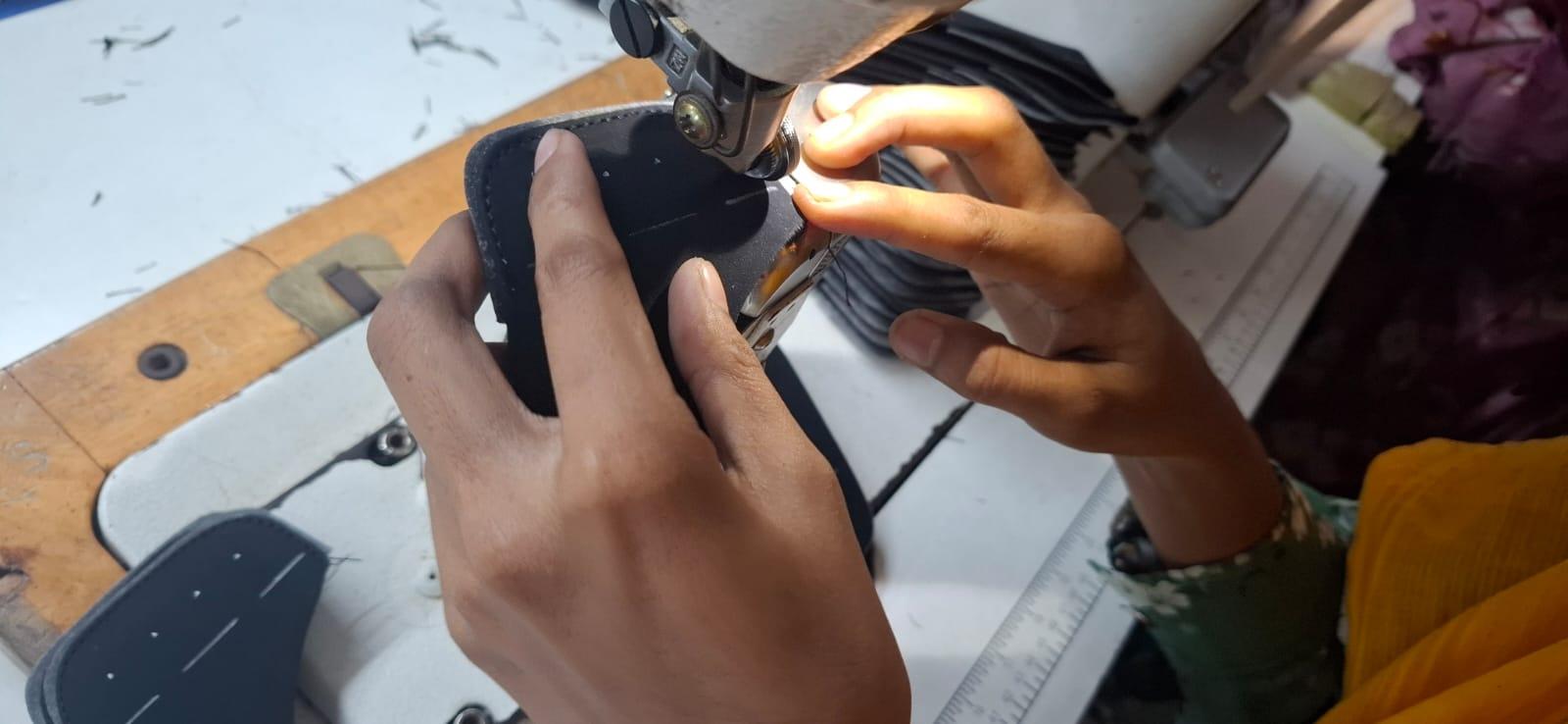 Close-up of hands guiding material through a sewing machine