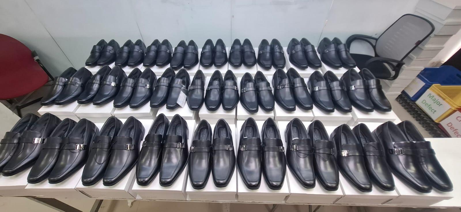 Finished footwear arranged for final quality inspection with defect sorting bins
