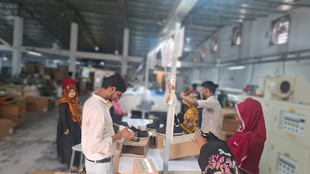 Workers inspecting and packing sneakers during inline quality checks