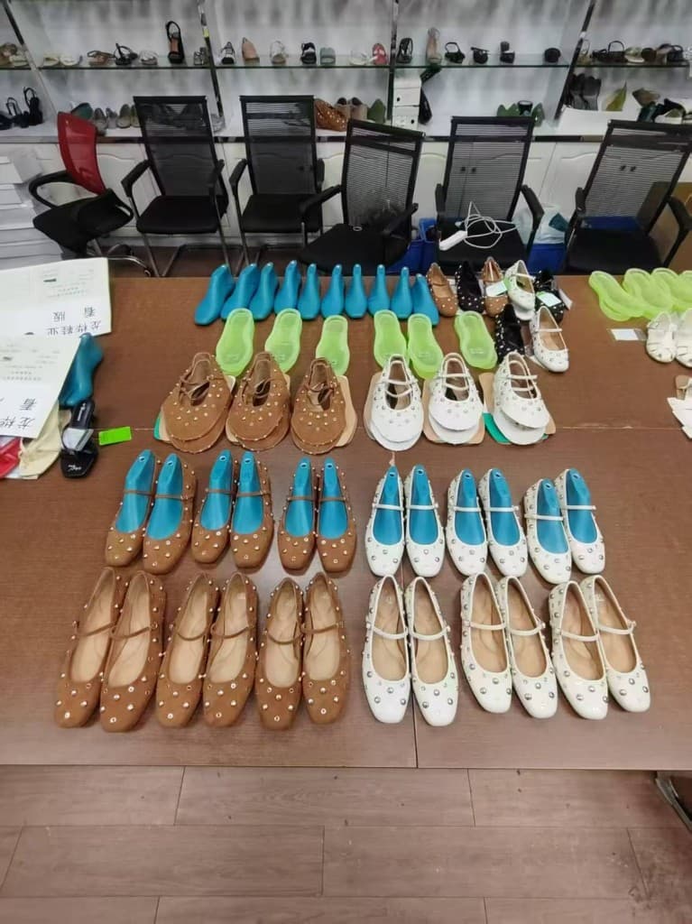 Ballet flat samples, lasts, and uppers laid out for pre-production review